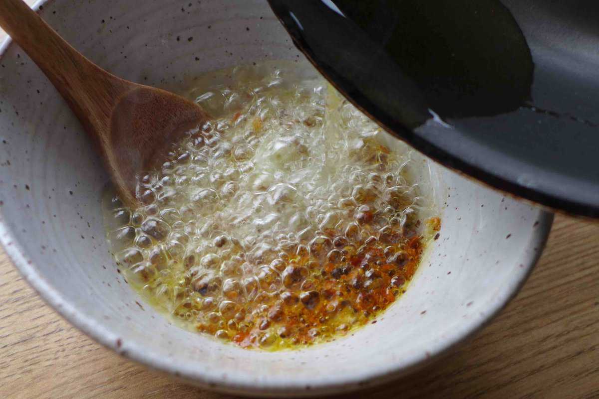 pouring hot oil over spices.