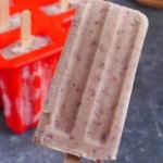 one red bean popsicle held by a hand.