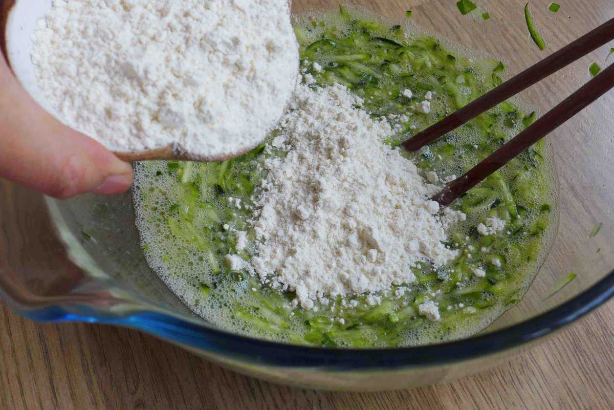 Adding flour to grated zucchini.