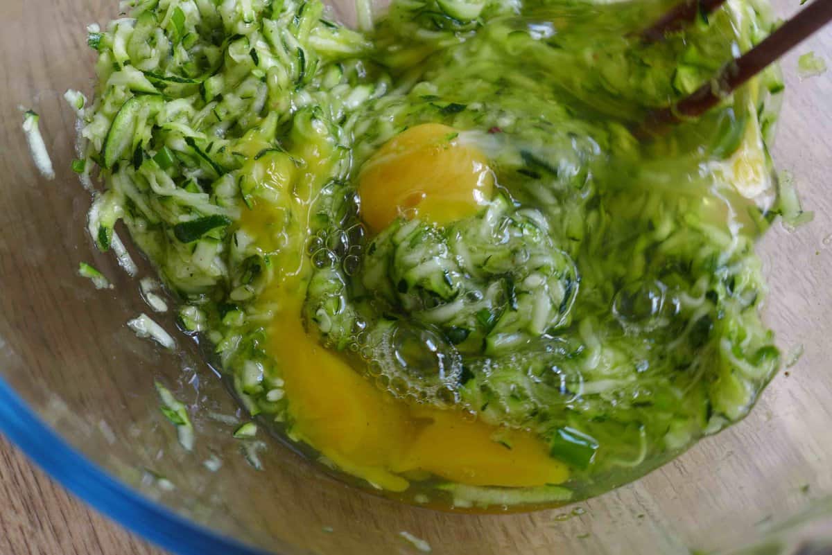 mixing eggs with grated zucchini.