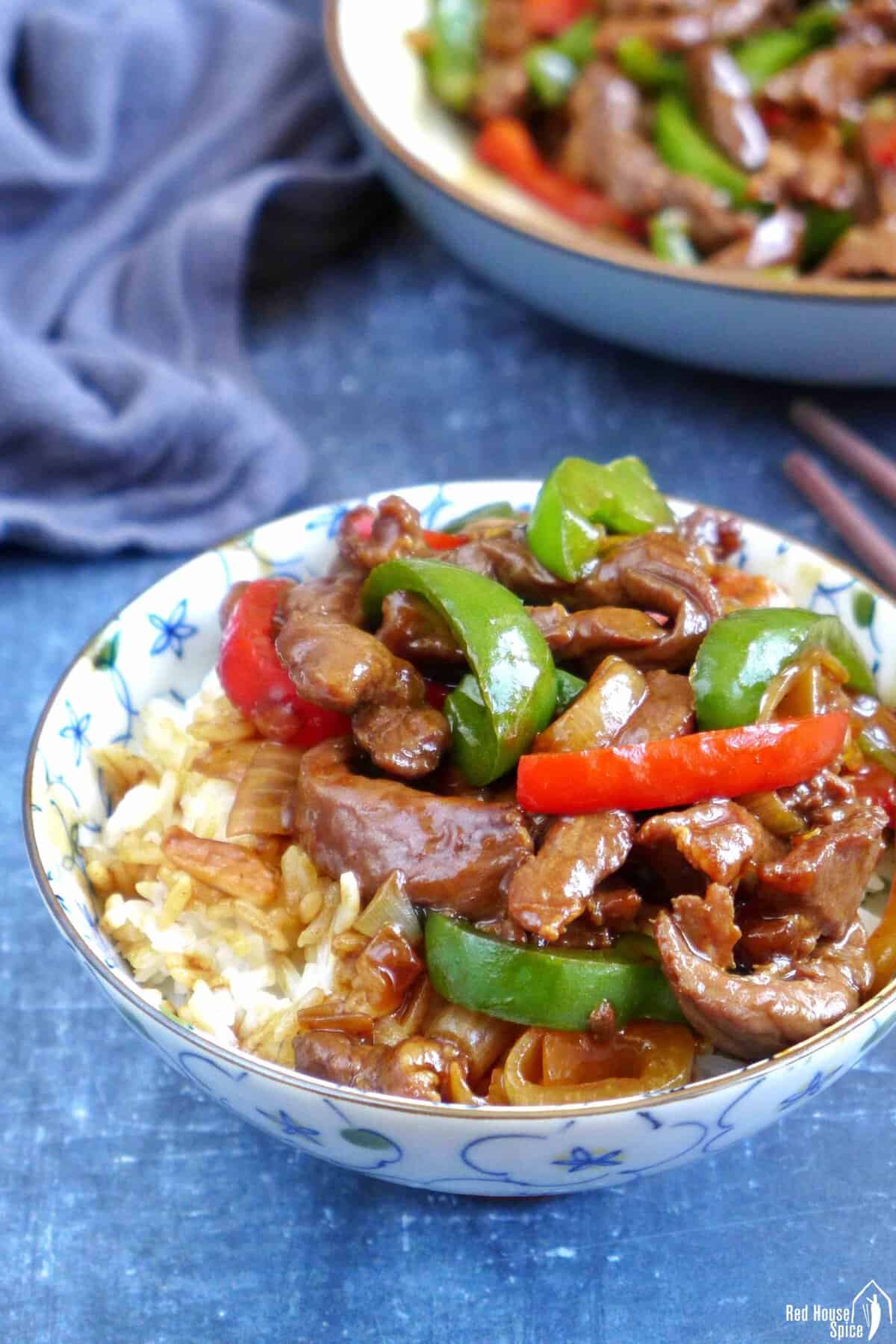 pepper steak over a bowl of rice.