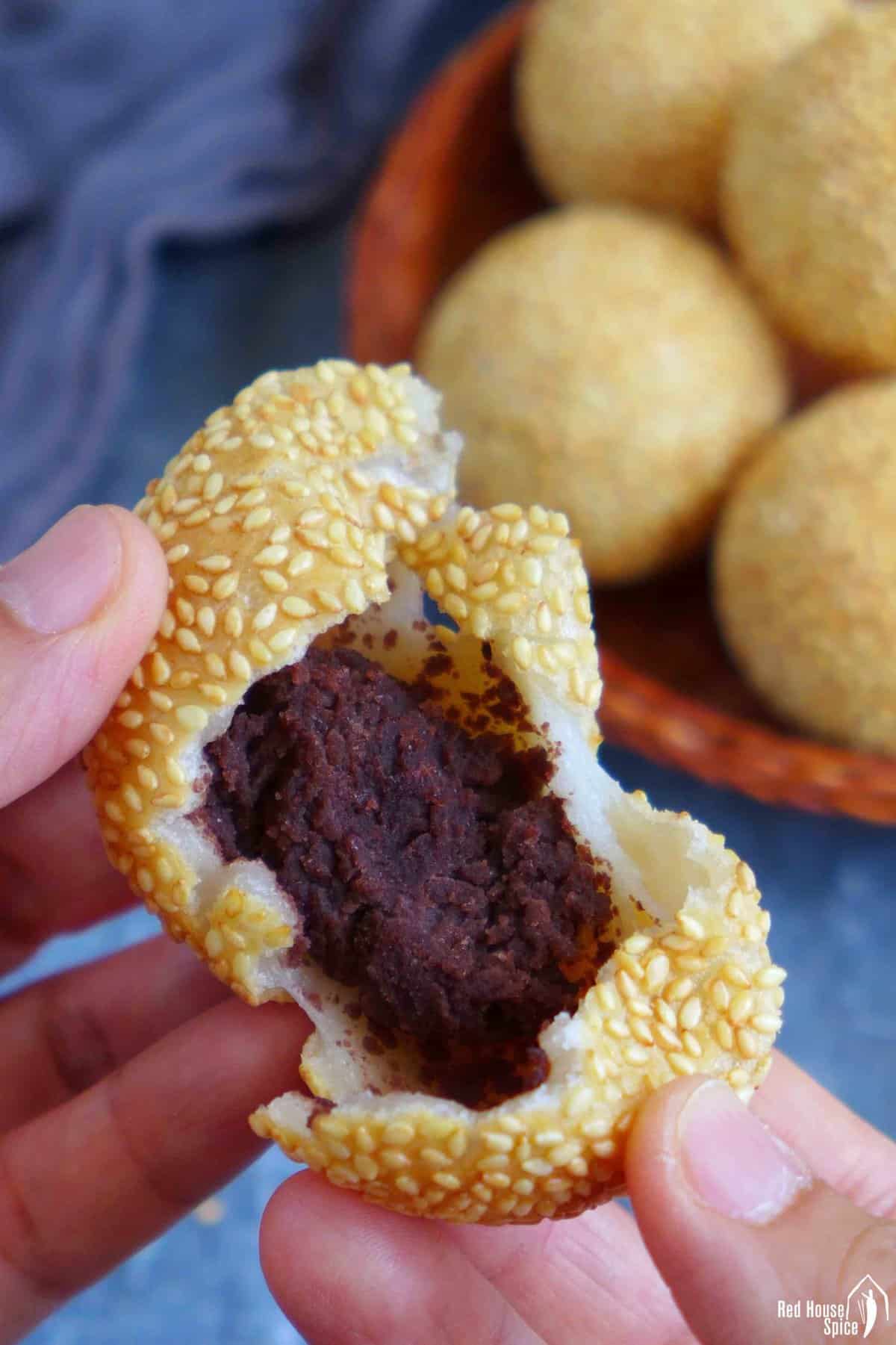 An torn open sesame ball with red bean paste filling.