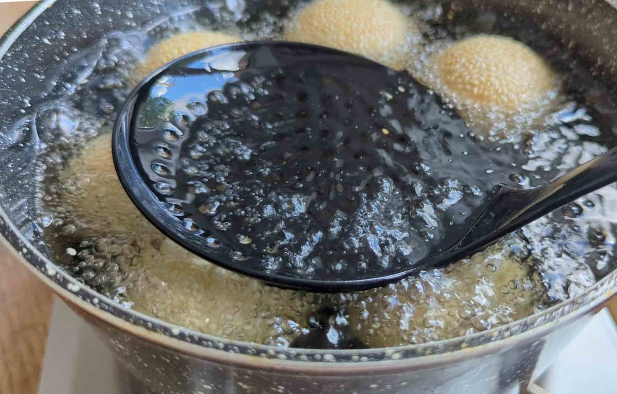 pressing sesame balls under the oil.