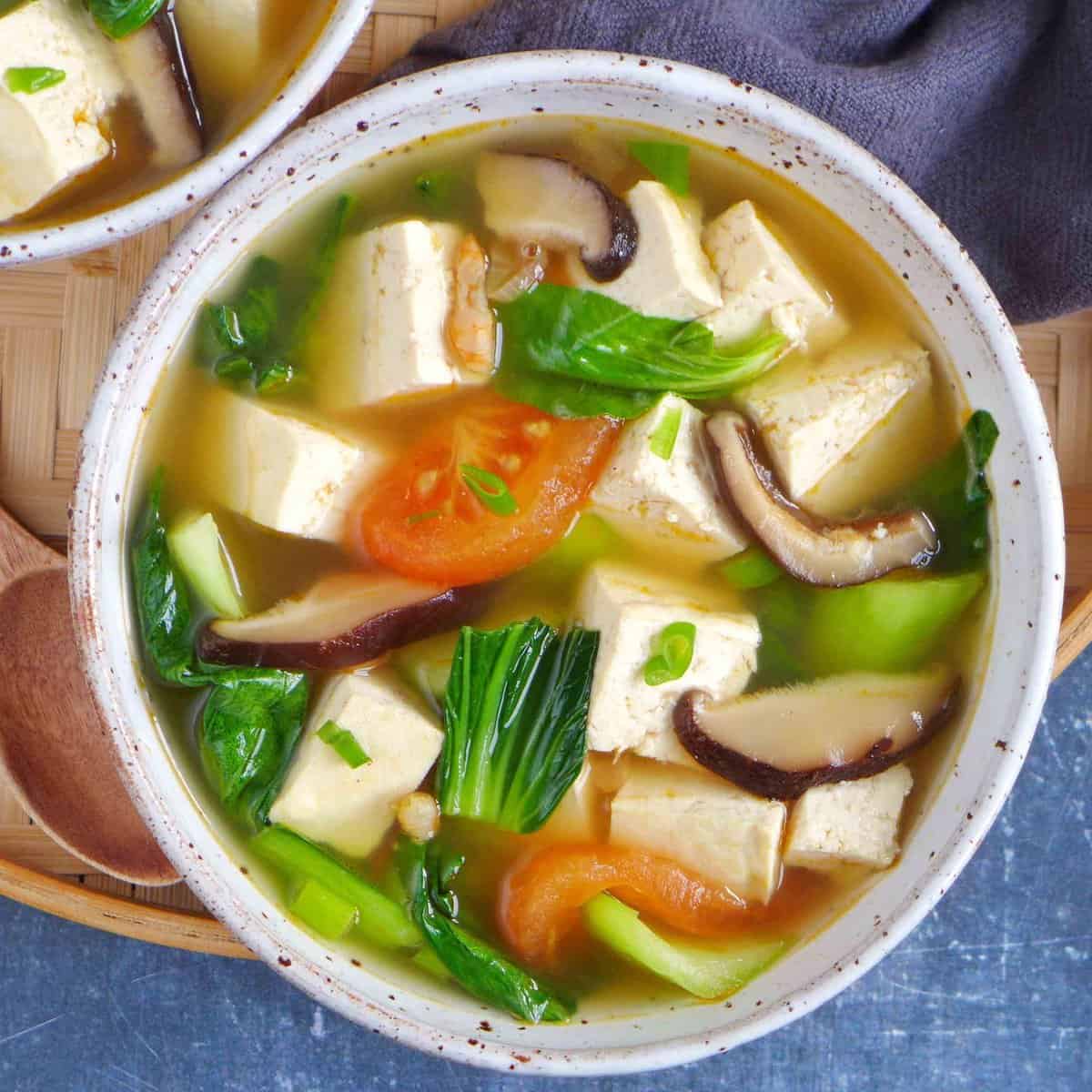 a bowl of Chinese tofu soup with vegetables.