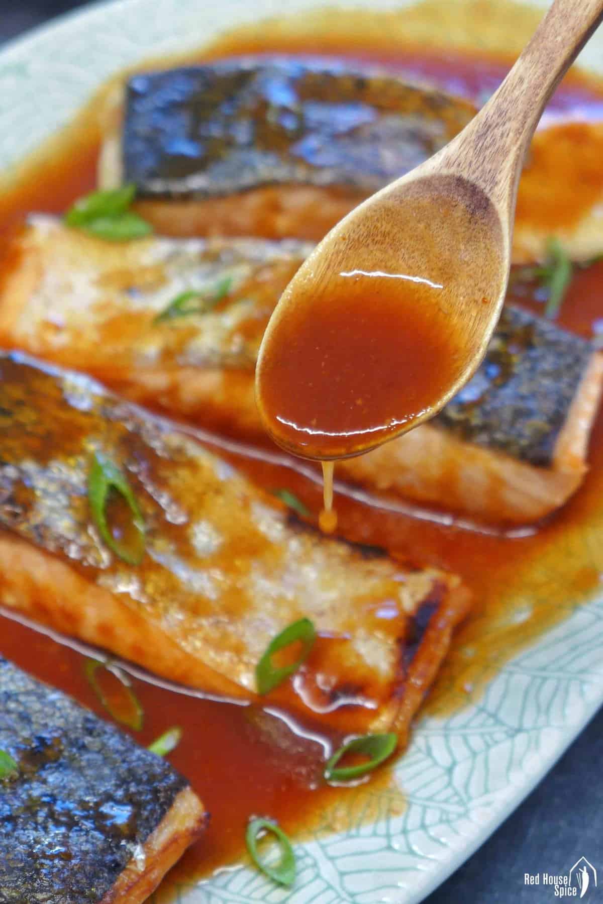 adding sweet and sour sauce to roast salmon filets.