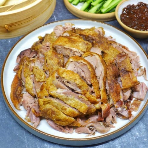 A plate of aromatic crispy duck cut into pieces.