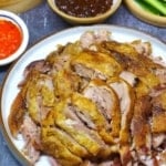 A plate of aromatic crispy duck and buns, vegetables and sauces on the side with overlay text that says aromatic crispy duck.