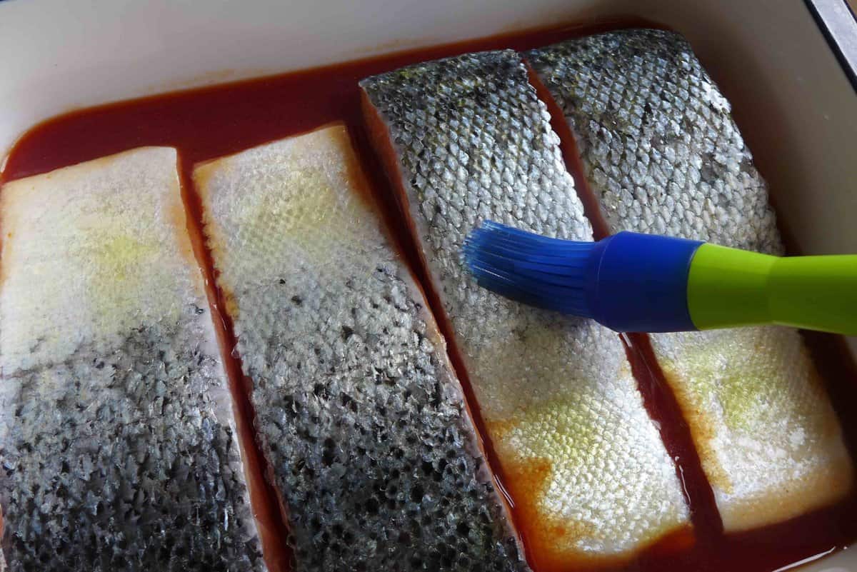 brushing olive oil over salmon skin.