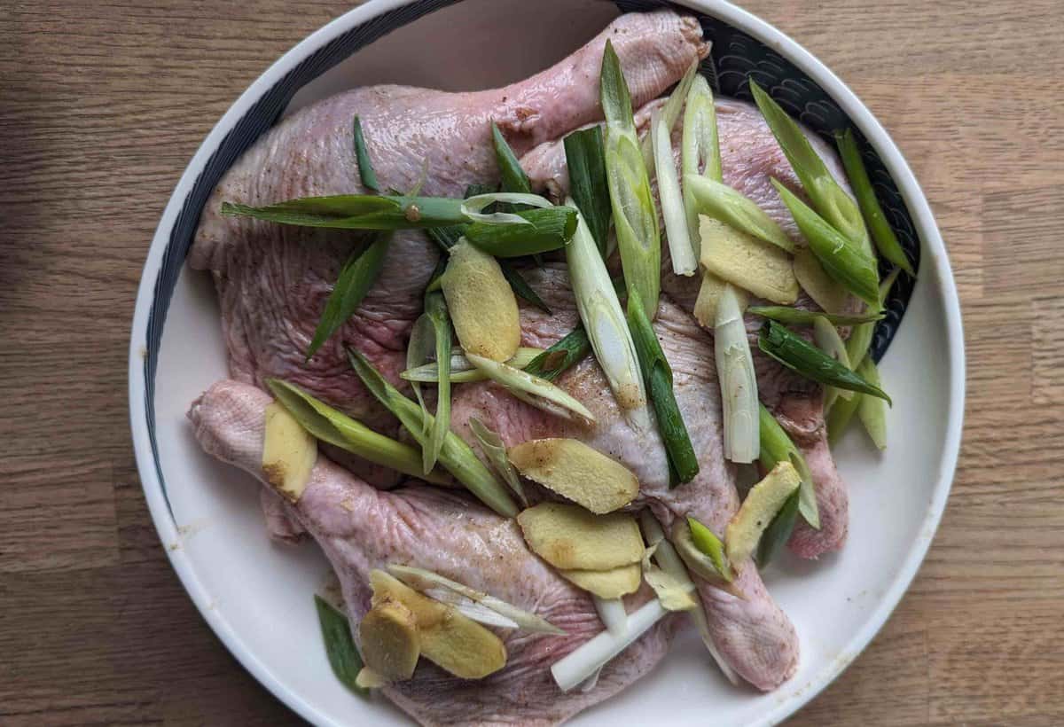 marinating duck legs with salt, spices and aromatics.