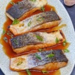 four pieces of roast salmon filets with sweet and sour sauce.