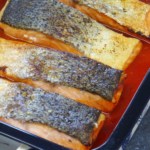 roast salmon filets with sauce in a roasting dish.