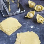 wonton wrappers with stuffed wontons and a pasta machine.