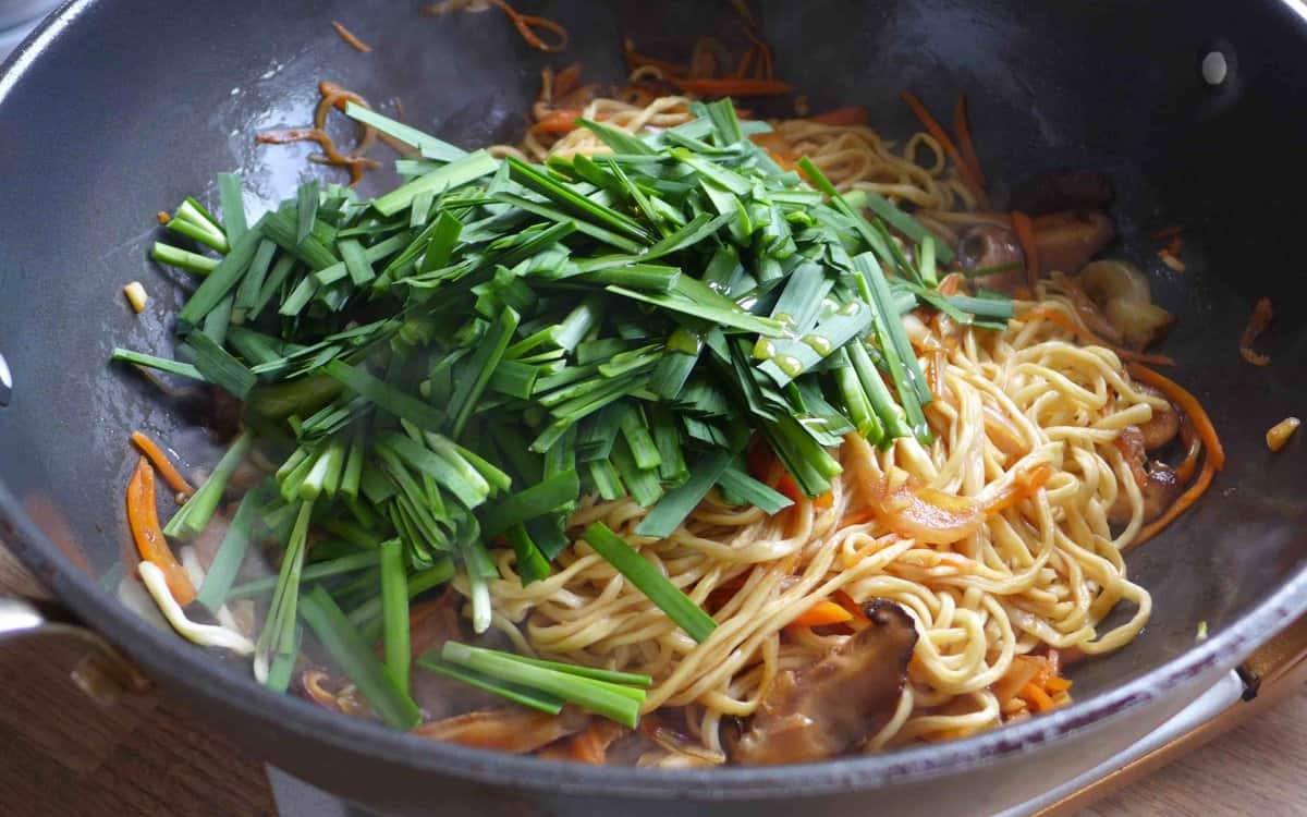 adding Chinese chives to noodles.