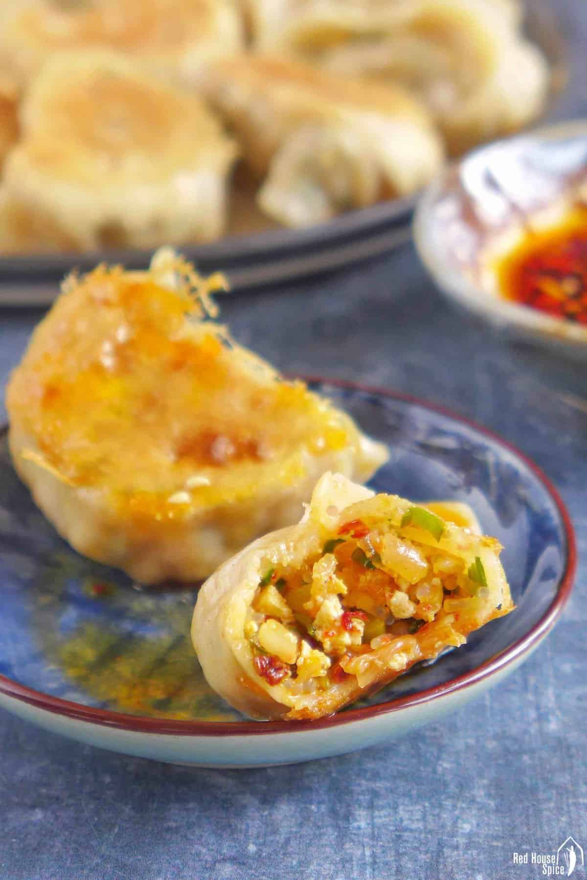 an open dumpling showing its kimchi filling with other ingredients.