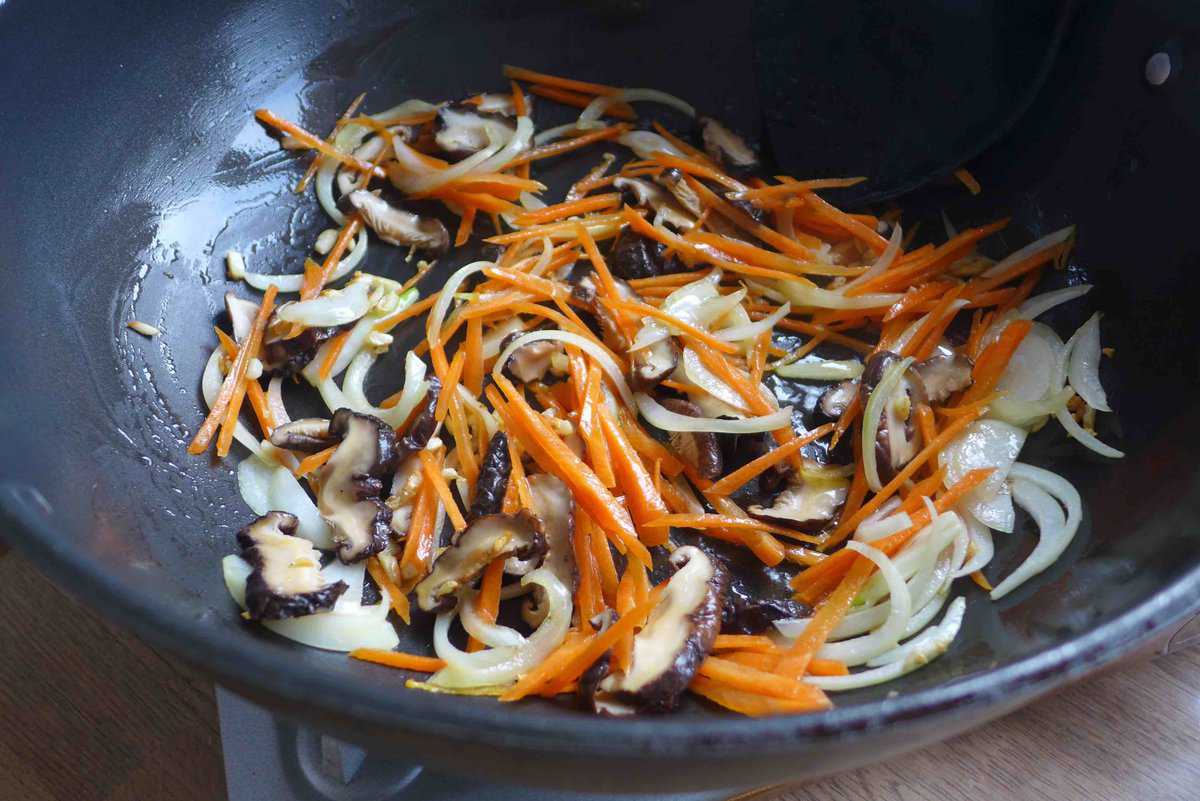 stir-frying carrot, onion and mushrooms.