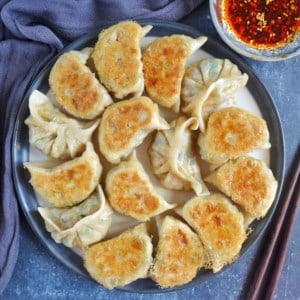 a plate of pan-fried dumplings with kimchi tofu filling.