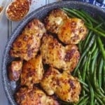 Chicken thighs and green beans in a skillet with overlay text that says chili cumin chicken.