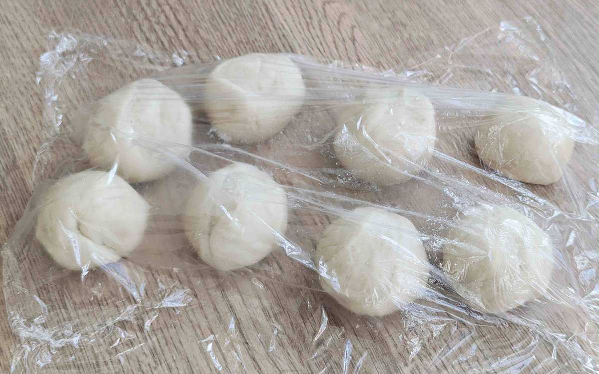 dough balls under plastic wrap.