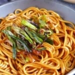 sauce coated noodles with fried scallions with overlay text that says scallion oil noodles.