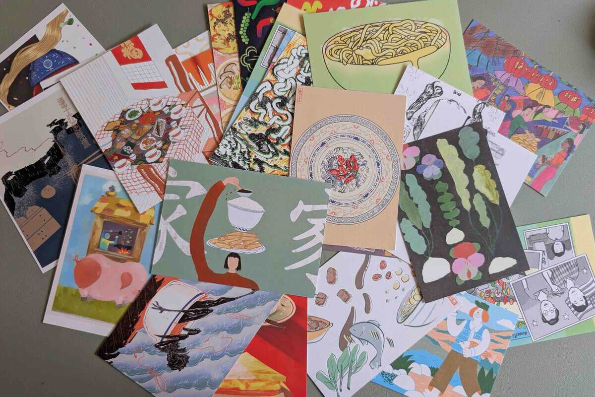 illustrated postcards spread on a desk.