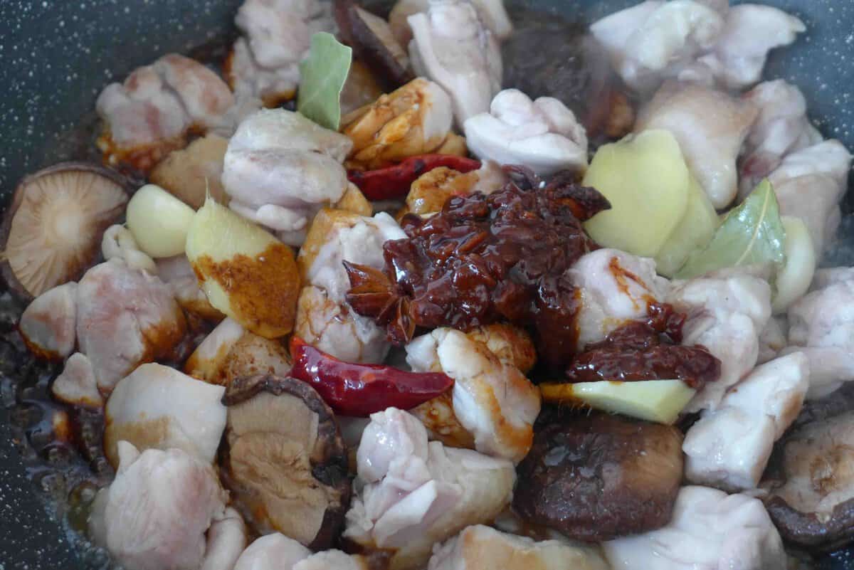 adding yellow bean sauce and soy sauce to chicken.